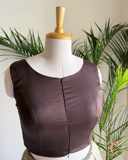 Close-up of the contemporary notched neckline and dual front zip detail on the premium emerald green blouse.
