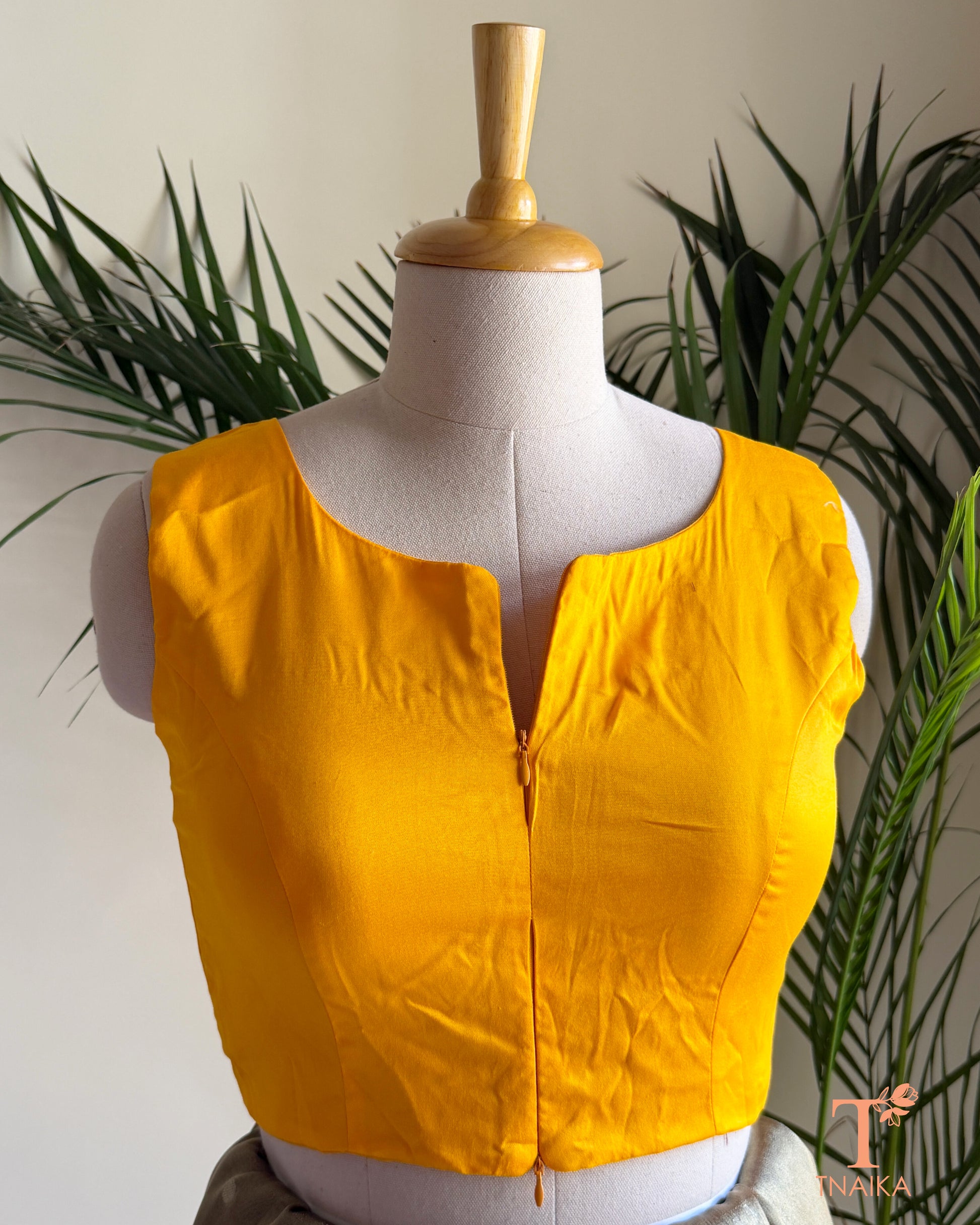 Cotton Silk sleeveless blouse featuring a modern notched round neckline and adjustable dual front zipper.