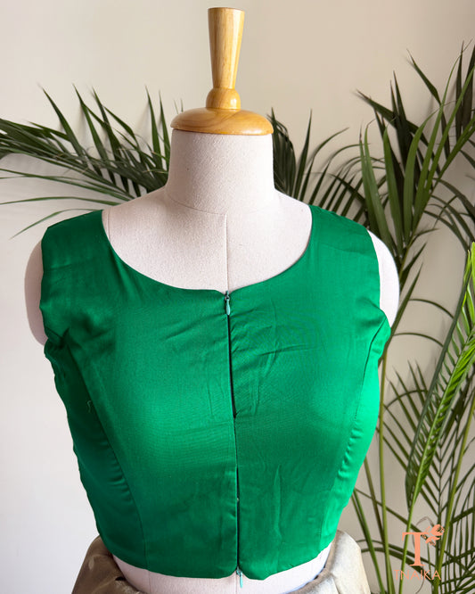 Close-up of the contemporary notched neckline and dual front zip detail on the premium emerald green blouse.
