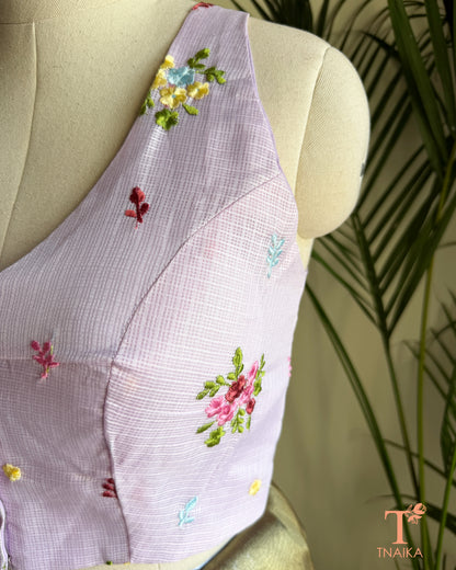 Close-up of premium Kota silk blouse showcasing handcrafted floral embroidery and fine textured fabric.