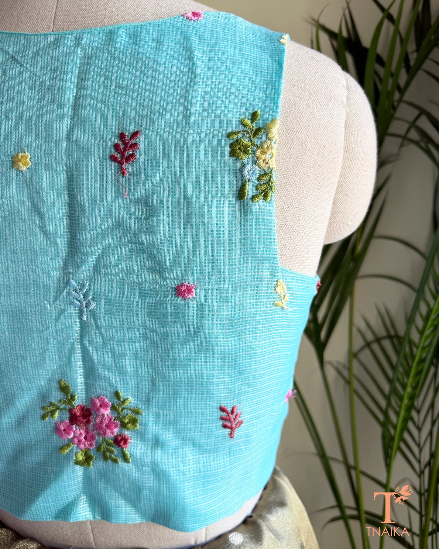 Close-up of premium Kota silk blouse showcasing handcrafted floral embroidery and fine textured fabric.
