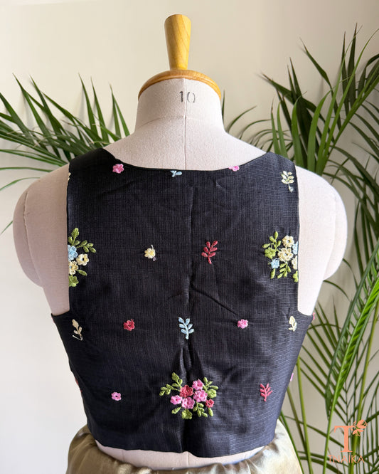 Back view of premium embroidered Kota silk blouse featuring delicate floral motifs, soft pastel embroidery, and a structured tailored finish.