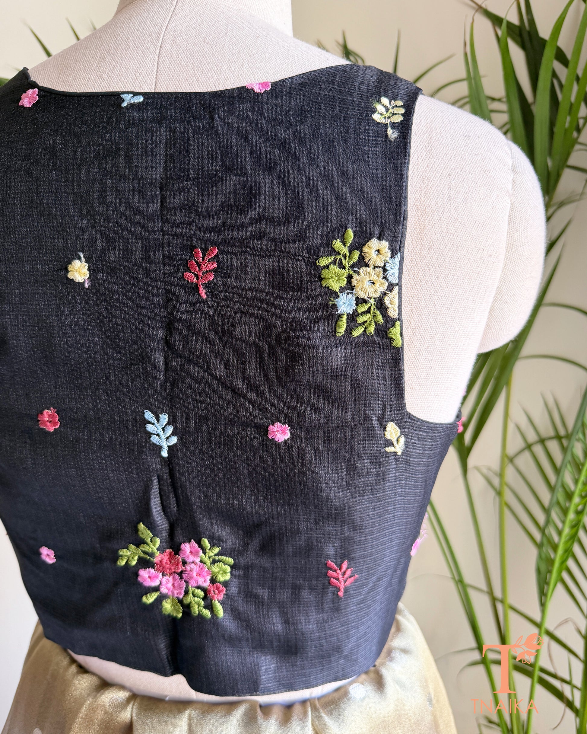 Close-up of premium Kota silk blouse showcasing handcrafted floral embroidery and fine textured fabric.