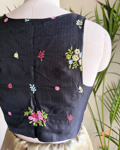 Close-up of premium Kota silk blouse showcasing handcrafted floral embroidery and fine textured fabric.