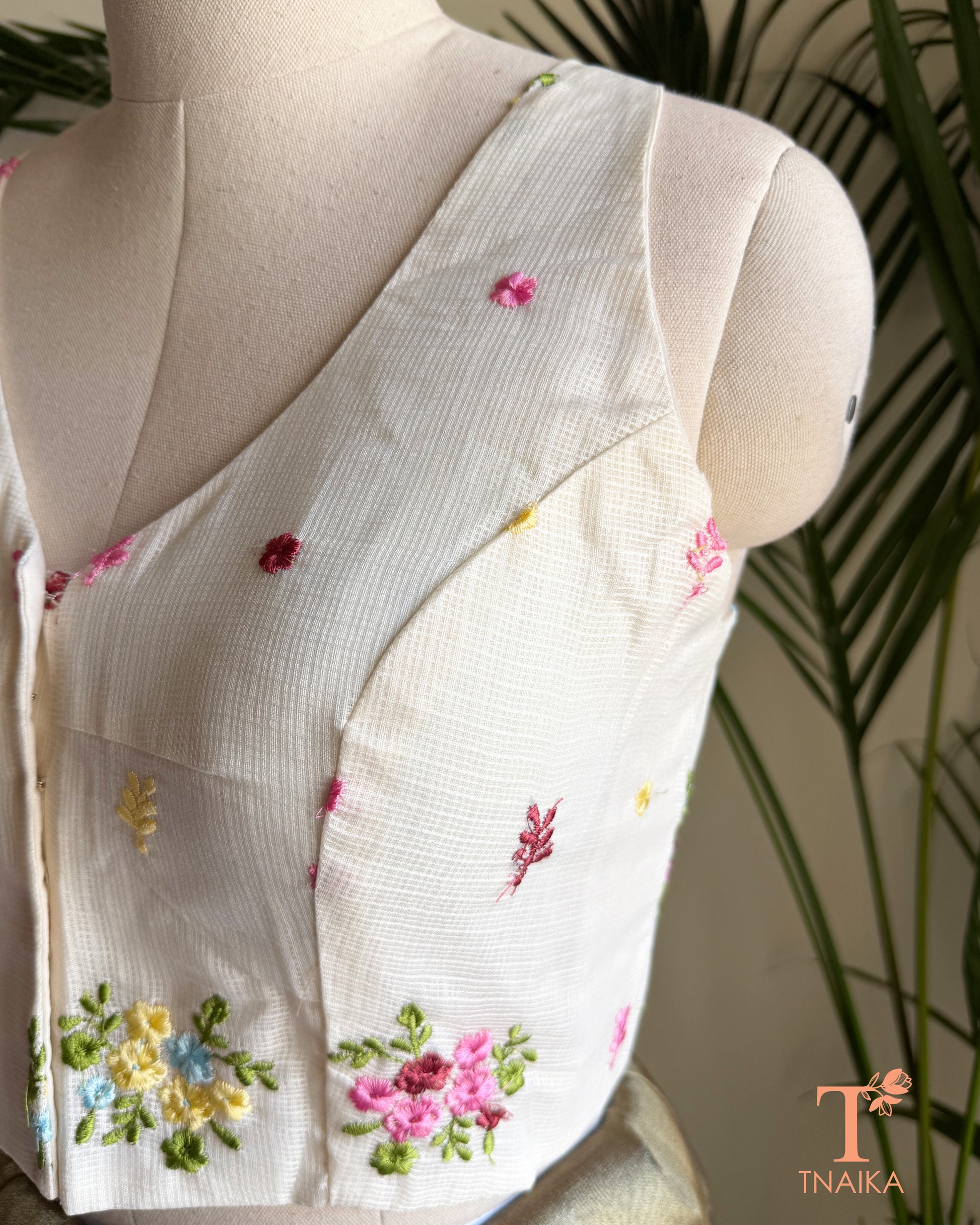 Close-up of premium Kota silk blouse showcasing handcrafted floral embroidery and fine textured fabric.
