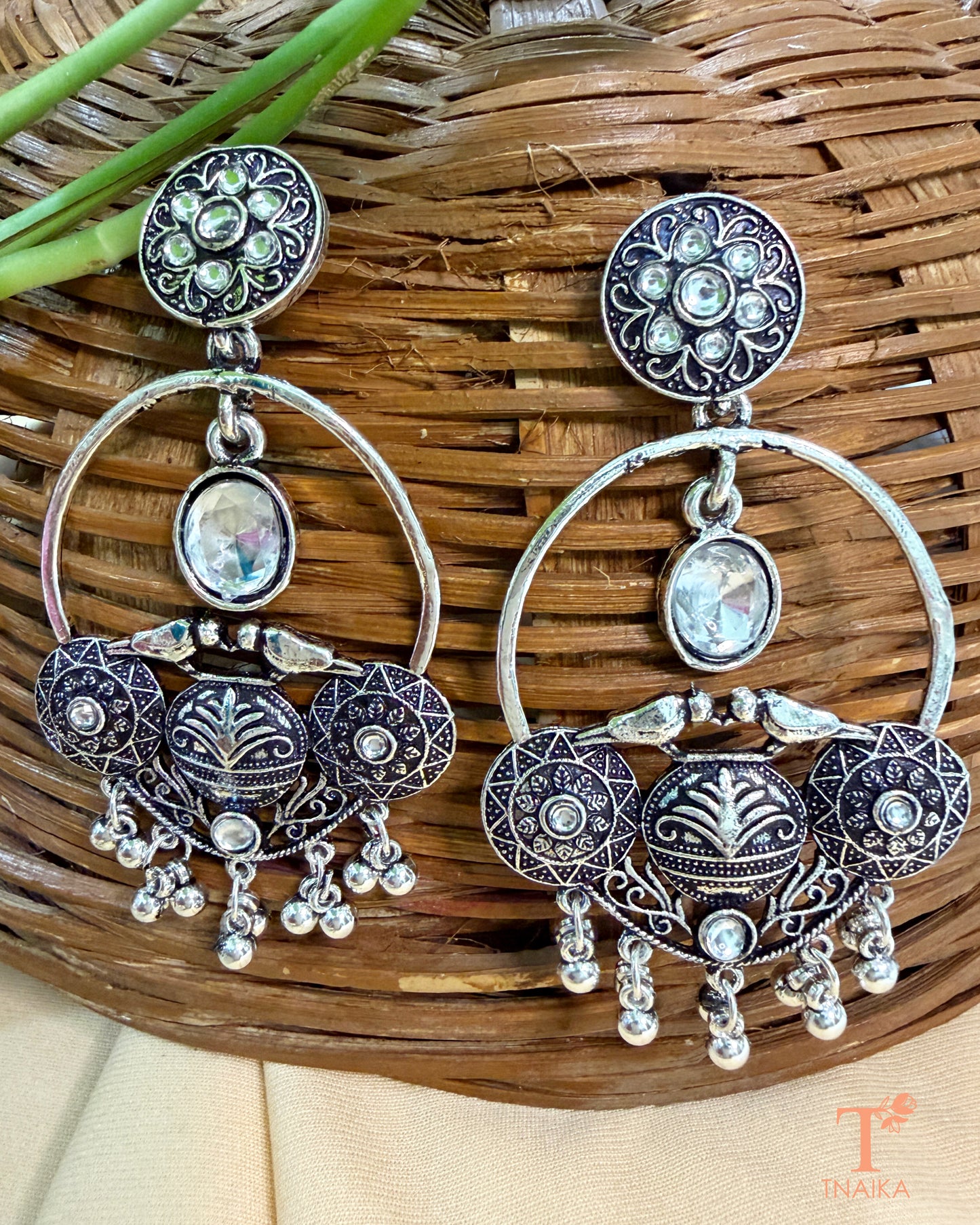 Traditional oxidised statement earrings featuring stones and dangling accents.