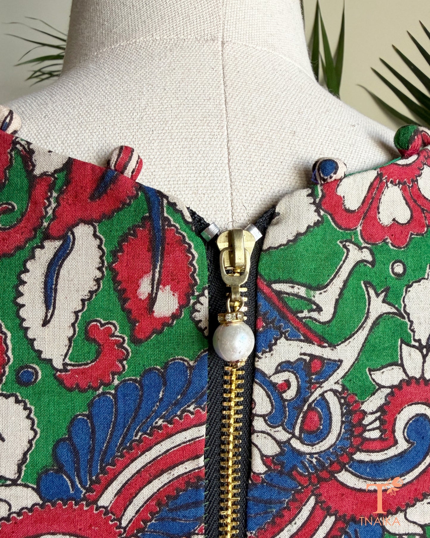 Back view of Tnaika™ Kalamkari cotton blouse showcasing an antique-finish zipper closure and all-over Kalamkari-inspired floral and peacock print.