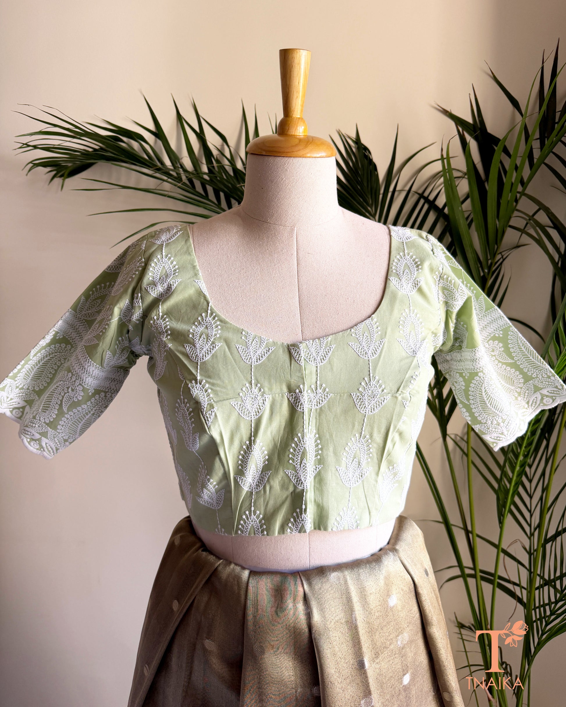 Front view of Tnaika™ pastel pistachio green embroidered cotton blouse with puff sleeves and round neck.
