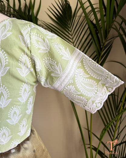 Close-up of the embroidered elbow-length sleeve with intricate Chikankari-inspired white embroidery on a pistachio green cotton blouse.