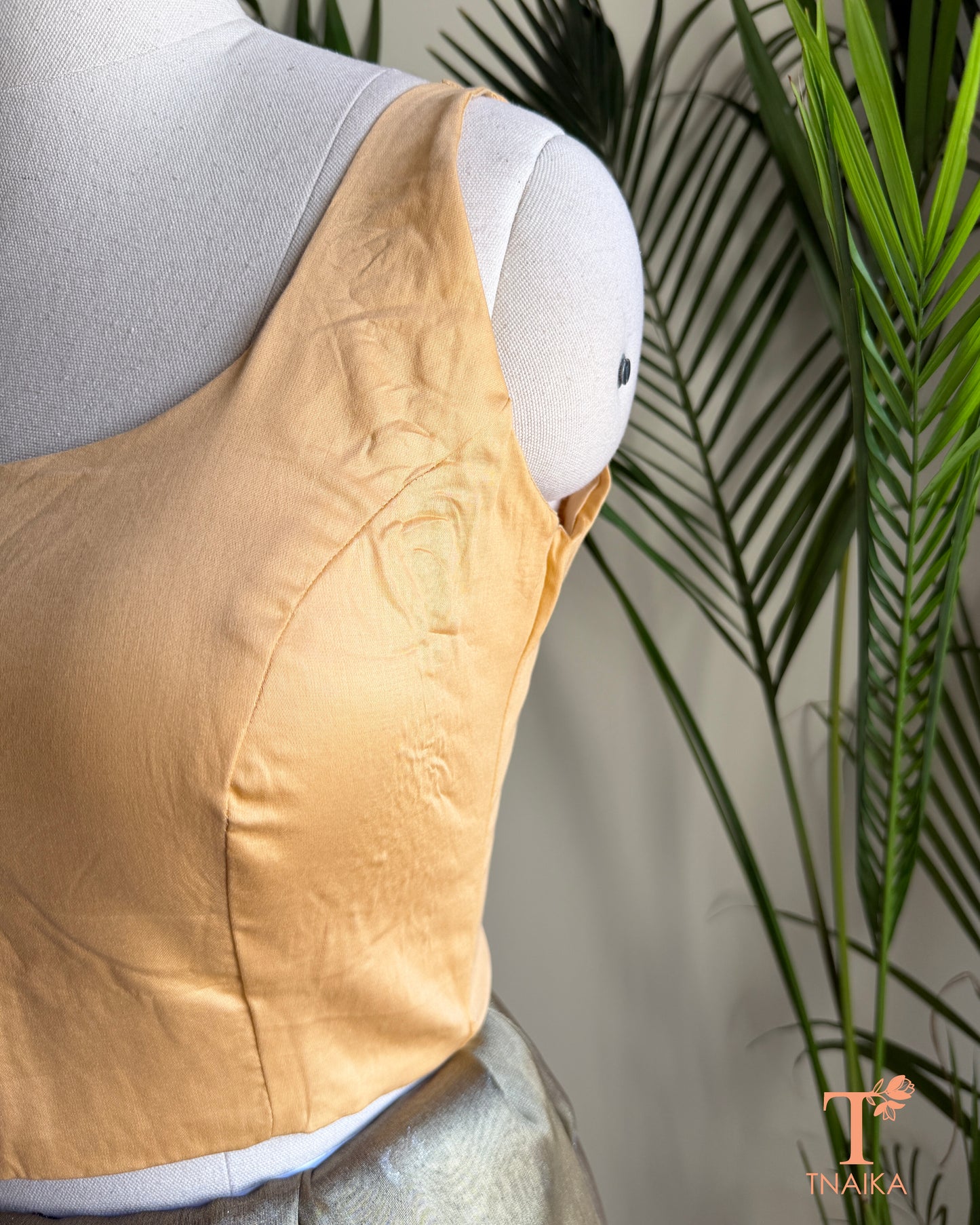 Side profile of blouse highlighting the princess-cut tailoring and smooth structured finish.