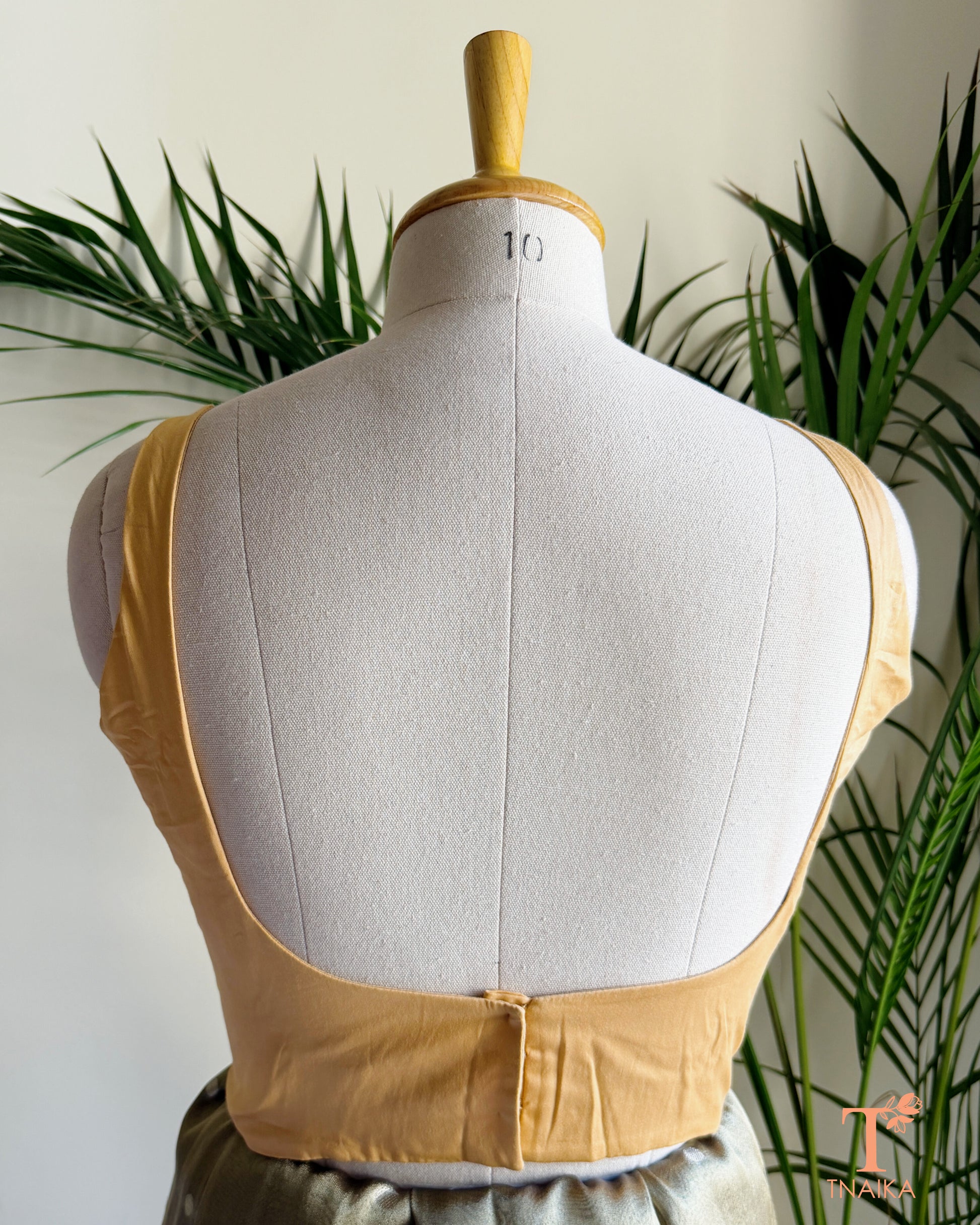 Back view of premium blouse featuring a deep U-shaped back and concealed hook closure.