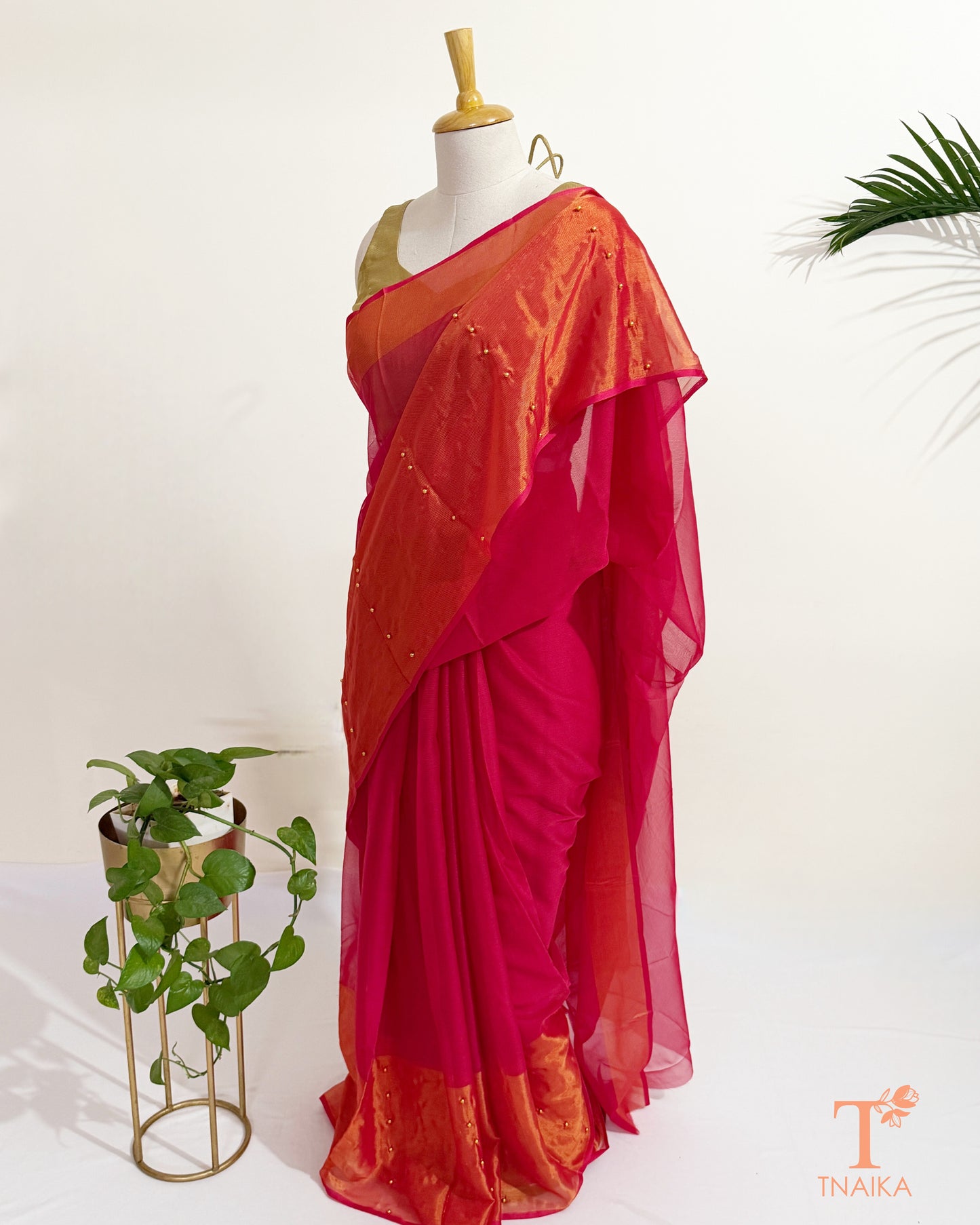 Designer hot pink chiffon saree with sheer pallu and pearl details.