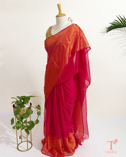 Designer hot pink chiffon saree with sheer pallu and pearl details.