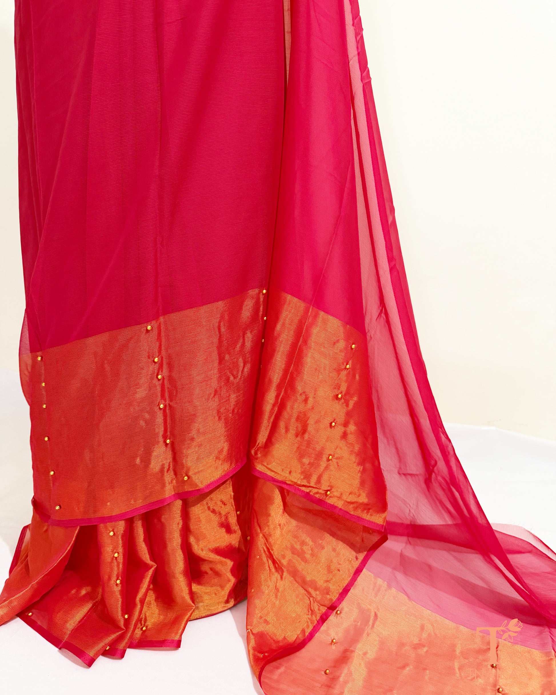 Lightweight chiffon saree featuring pearl embellished gold border.