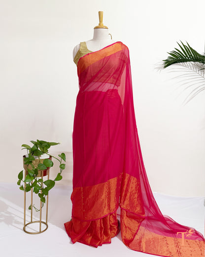 Hot pink pearl pinned chiffon saree with elegant golden border.