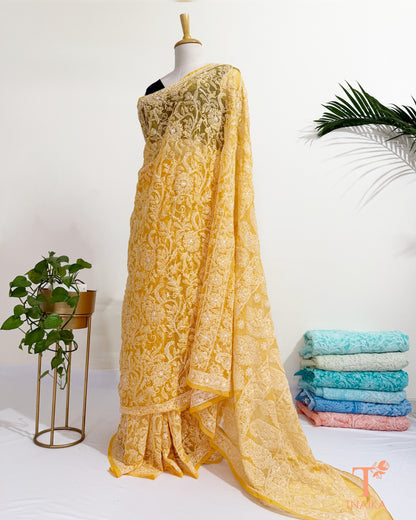 Lightweight embroidered yellow georgette saree with floral motifs.
