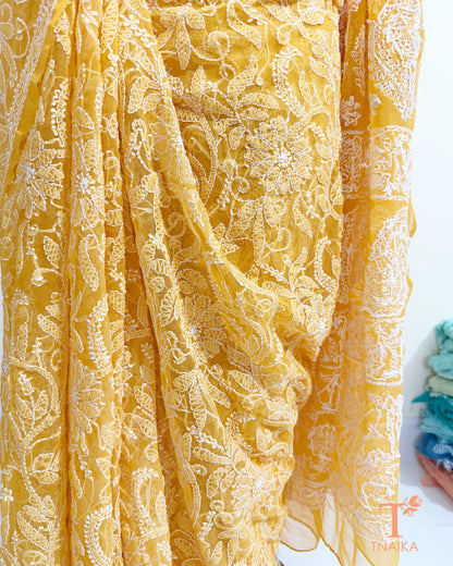 Festive yellow Chikankari saree with richly embroidered border.