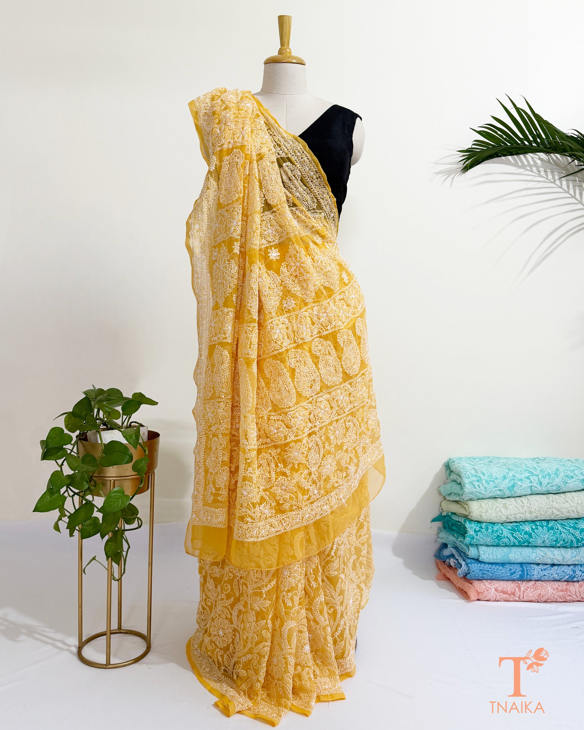 Yellow Chikankari georgette saree with intricate white floral embroidery.