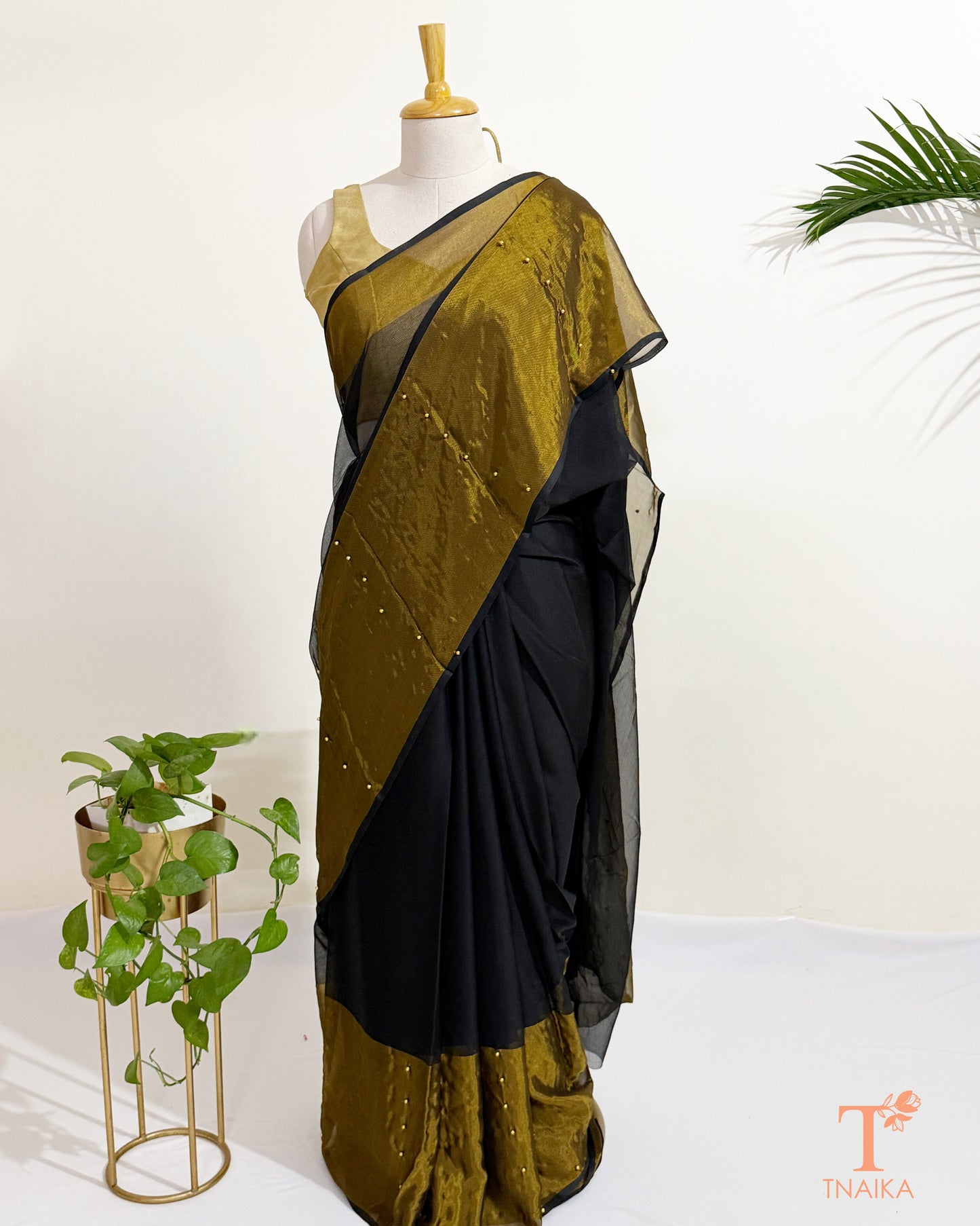 Premium black chiffon saree with antique gold border for festive wear.