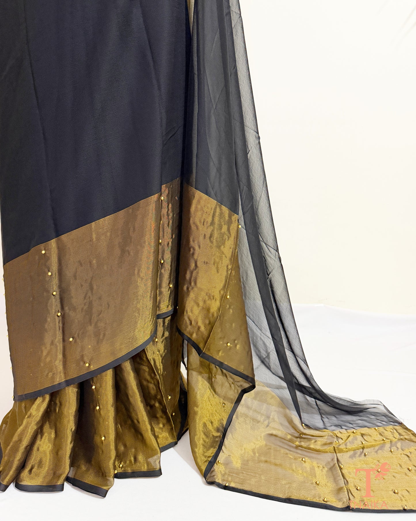 Sheer chiffon saree showcasing pearl embellishments and elegant drape.