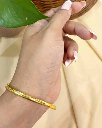 Ethnic brass cuff bracelet with green enamel centerpiece and ruby-toned kundan accents.