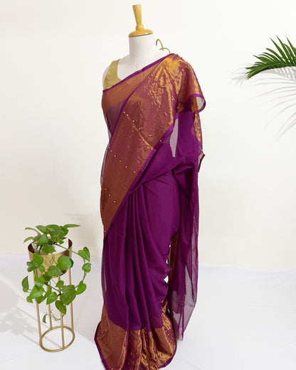 Chiffon saree with antique gold tissue border and pearl pin embellishments.