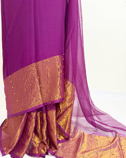 Elegant pearl pinned chiffon saree featuring a metallic gold border.