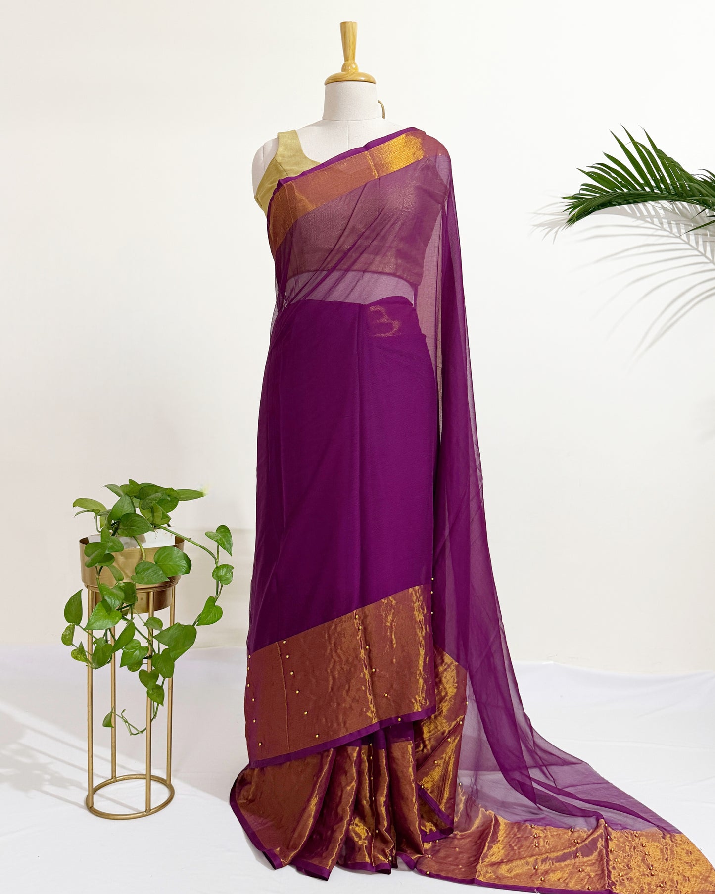 Premium chiffon saree with antique gold border for festive wear.