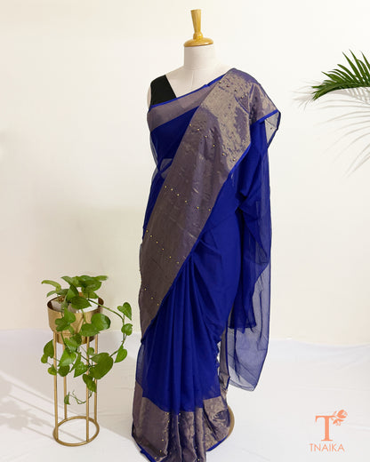 Chiffon saree with antique gold tissue border and pearl pin embellishments.