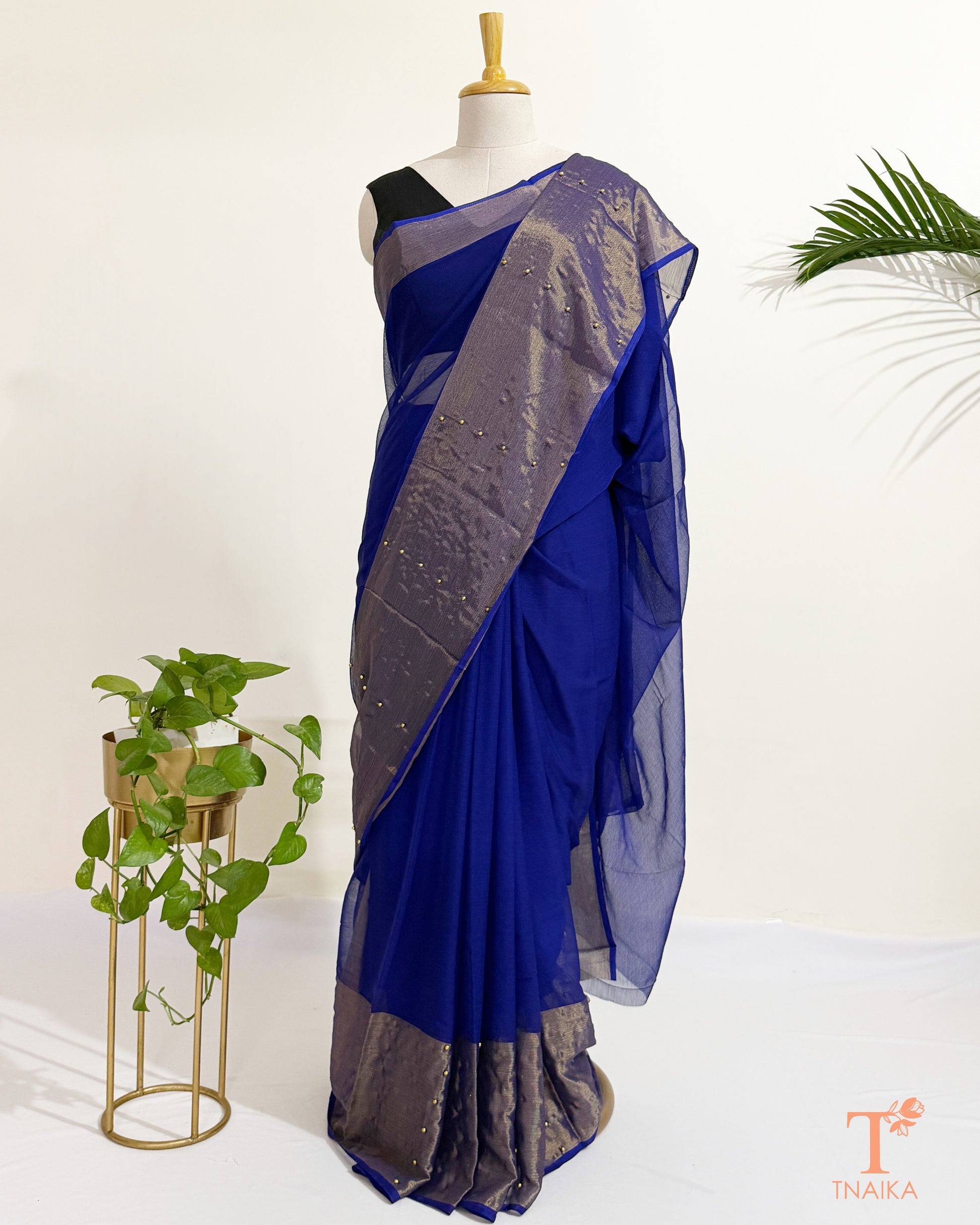 Elegant pearl pinned chiffon saree featuring a metallic gold border.