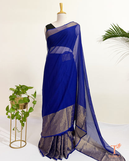 Premium chiffon saree with antique gold border for festive wear.