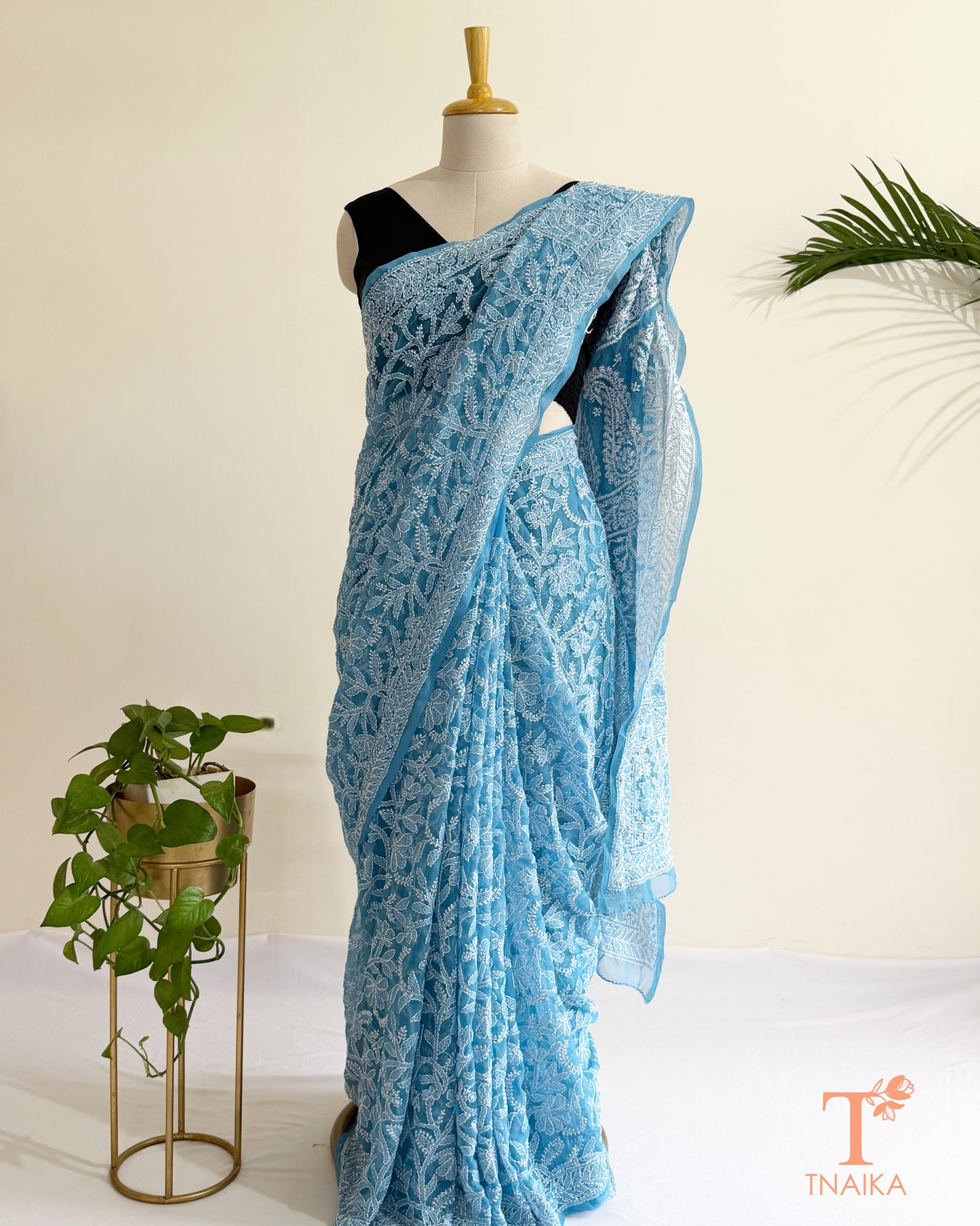 Handcrafted powder blue Chikankari saree with delicate white embroidery and floral patterns.