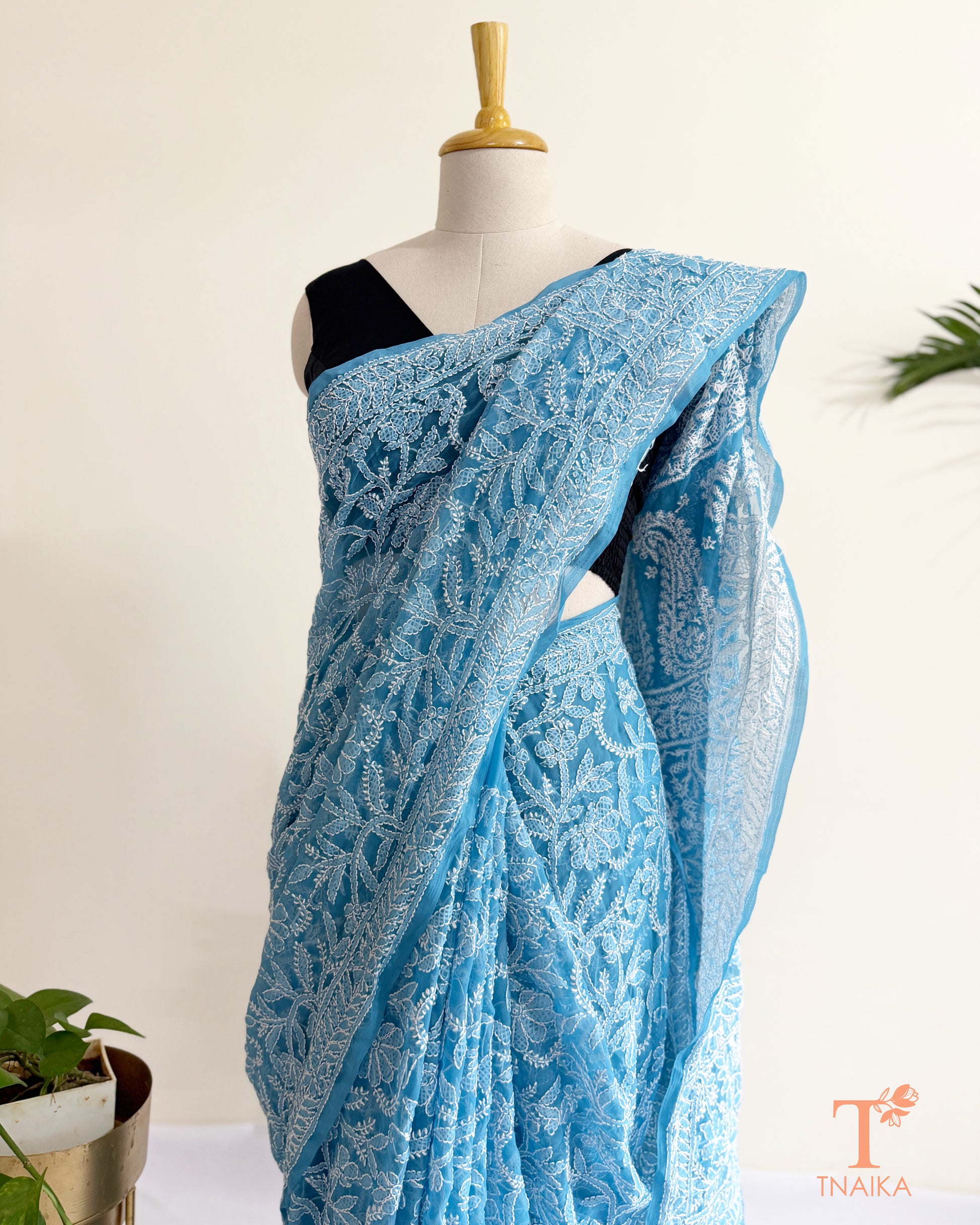 Soft powder blue Chikankari saree showcasing handcrafted white thread embroidery and ornate border.