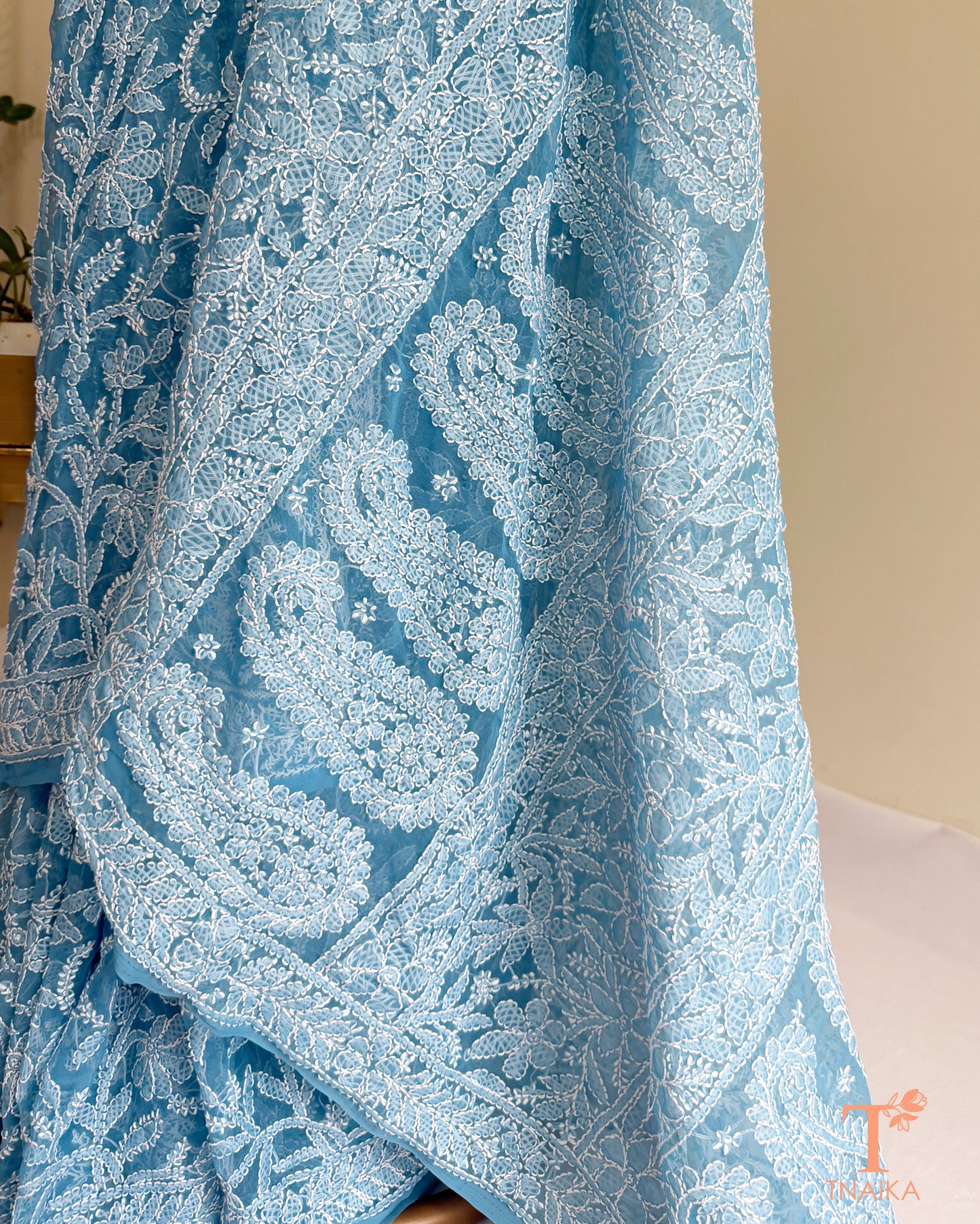 Elegant powder blue Chikankari embroidered saree featuring handcrafted floral and paisley threadwork.