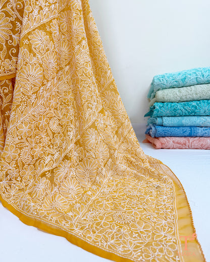 Elegant mustard yellow Chikankari saree featuring detailed embroidered pallu.