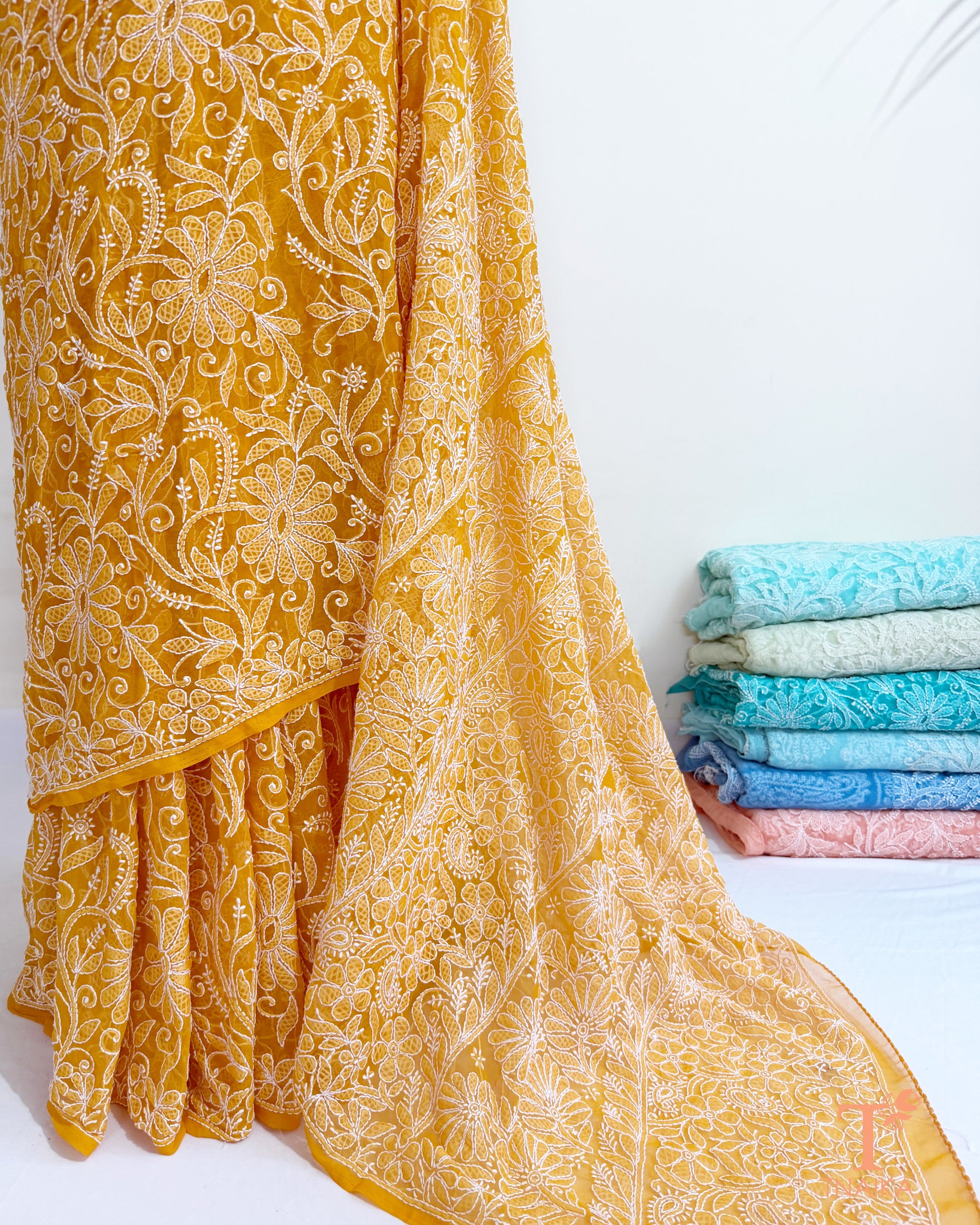 Yellow georgette saree with handcrafted paisley and floral embroidery.