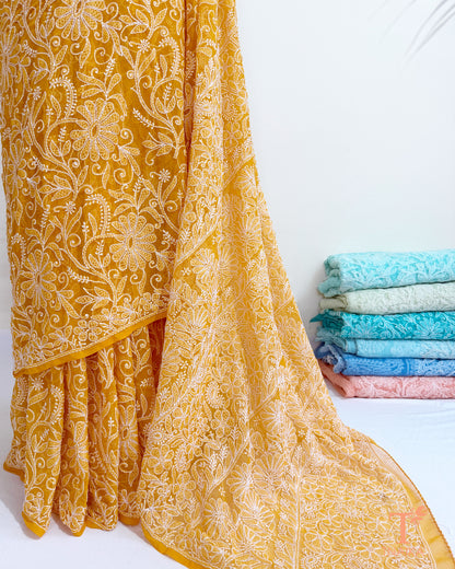 Yellow georgette saree with handcrafted paisley and floral embroidery.