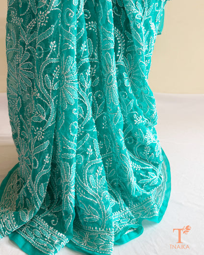 Designer turquoise teal Chikankari saree with detailed floral embroidery and elegant embroidered pallu.