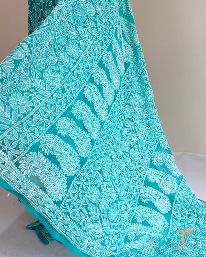 Premium turquoise teal Lucknowi Chikankari saree with intricate floral jaal embroidery.