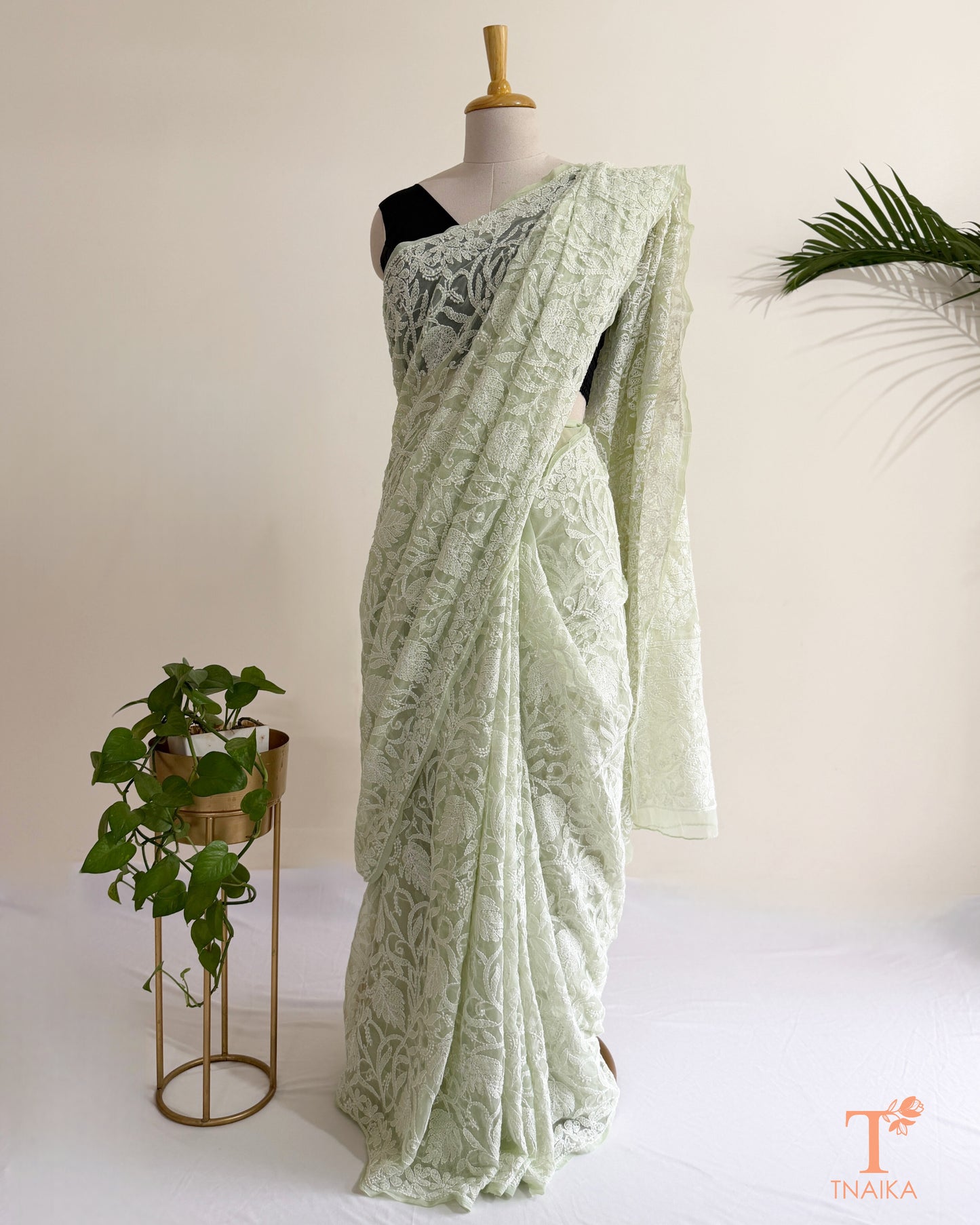 Premium mint green Lucknowi Chikankari saree with all-over white thread embroidery and delicate floral motifs.