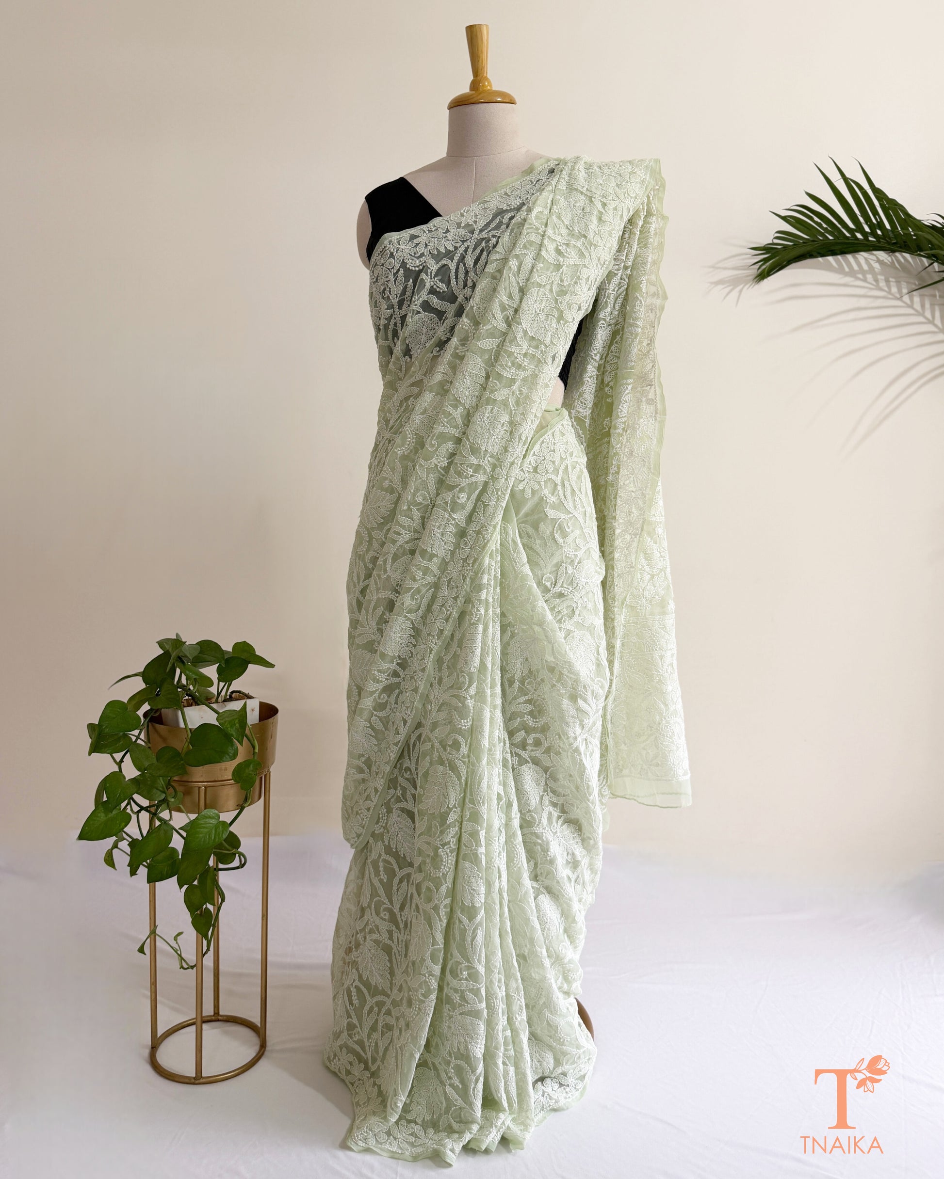 Premium mint green Lucknowi Chikankari saree with all-over white thread embroidery and delicate floral motifs.