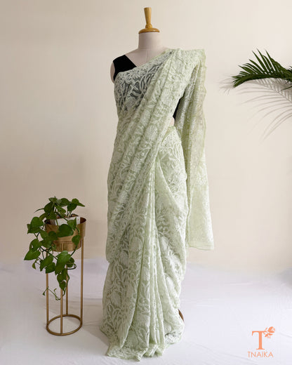 Premium mint green Lucknowi Chikankari saree with all-over white thread embroidery and delicate floral motifs.
