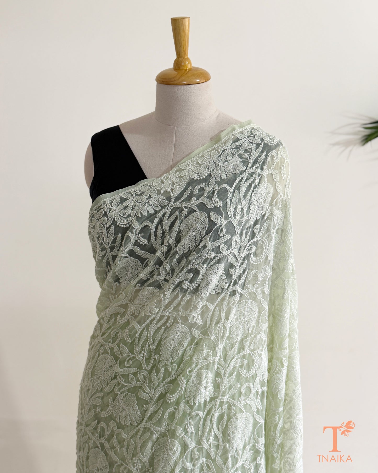 Soft mint green embroidered Chikankari saree showcasing intricate floral jaal and traditional white threadwork.