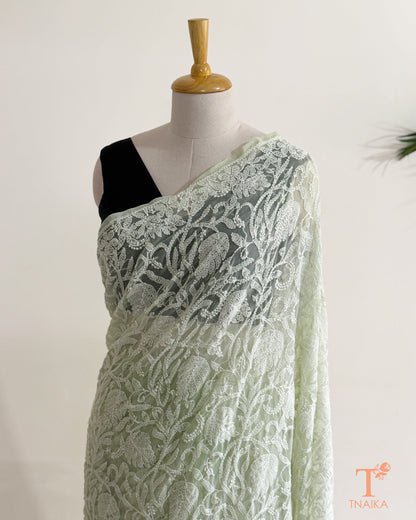 Soft mint green embroidered Chikankari saree showcasing intricate floral jaal and traditional white threadwork.