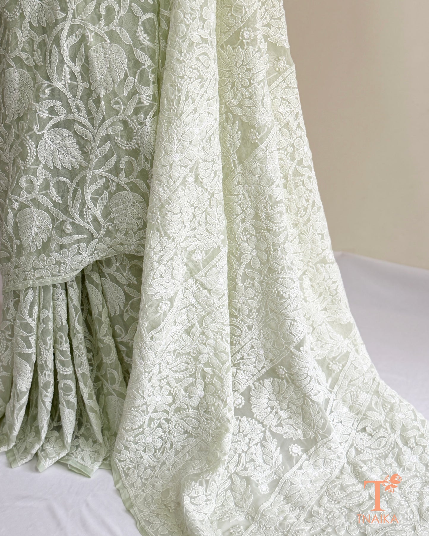 Handcrafted mint green Chikankari saree with detailed white embroidery and graceful embroidered borders.