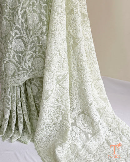 Handcrafted mint green Chikankari saree with detailed white embroidery and graceful embroidered borders.