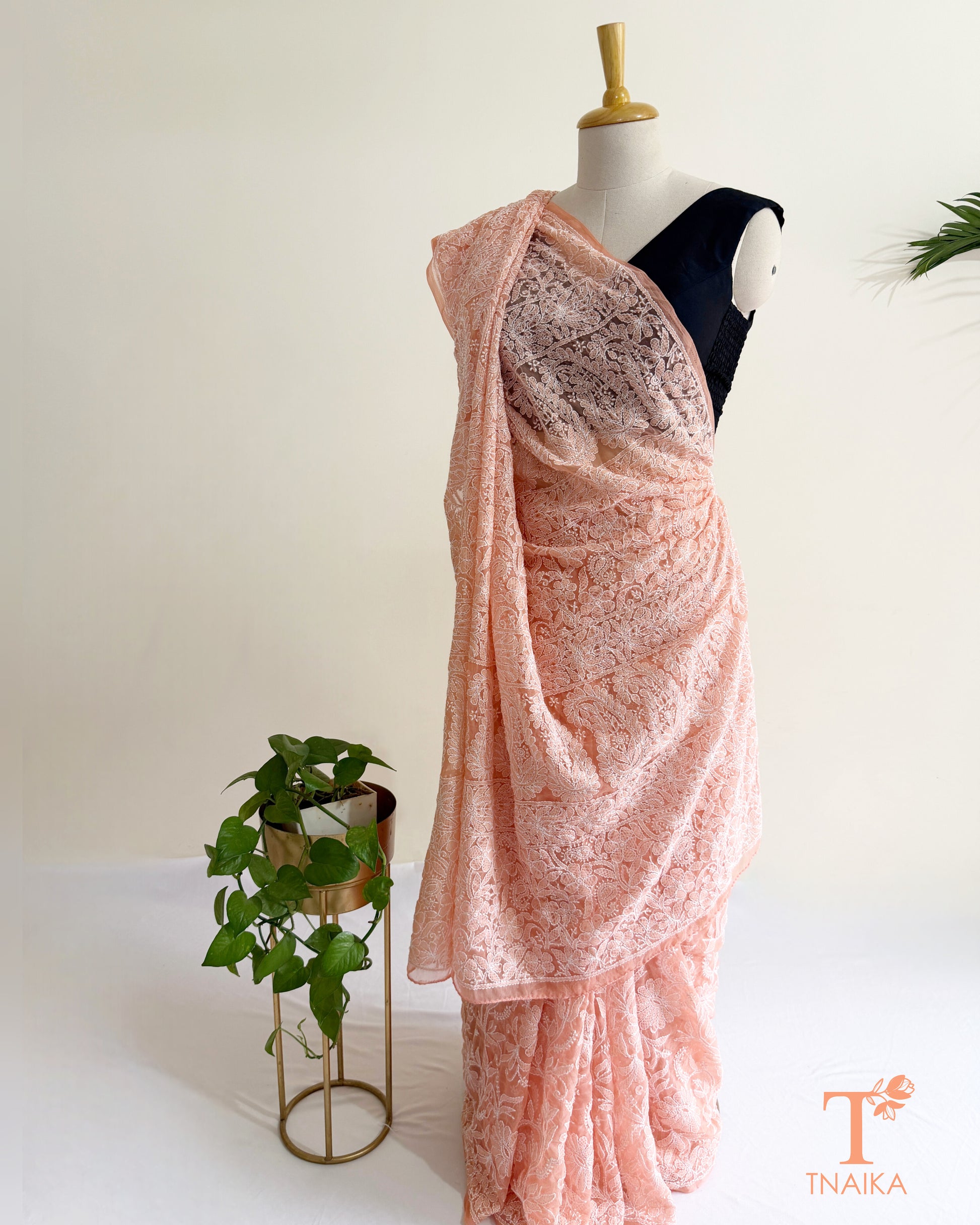 Premium blush pink Lucknowi Chikankari saree featuring handcrafted white floral embroidery and richly embroidered pallu.