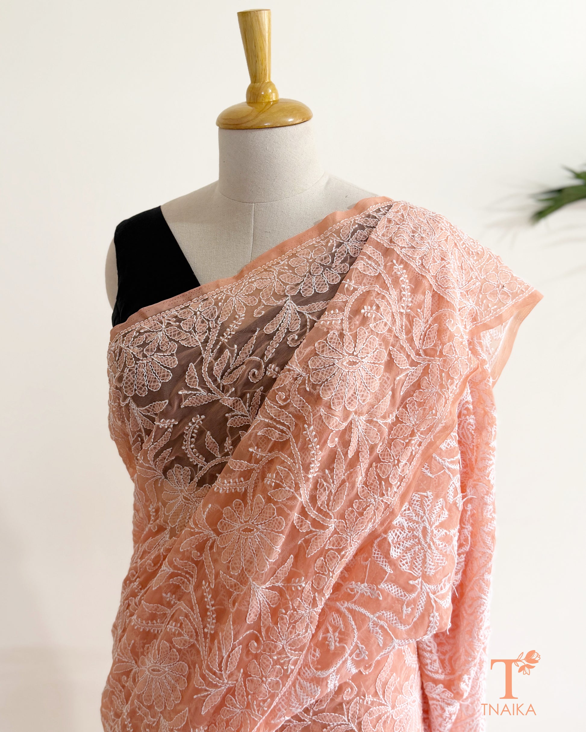 Soft blush pink embroidered Chikankari saree showcasing intricate floral jaal and traditional Lucknowi craftsmanship.