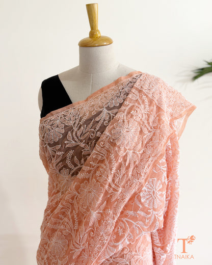 Soft blush pink embroidered Chikankari saree showcasing intricate floral jaal and traditional Lucknowi craftsmanship.
