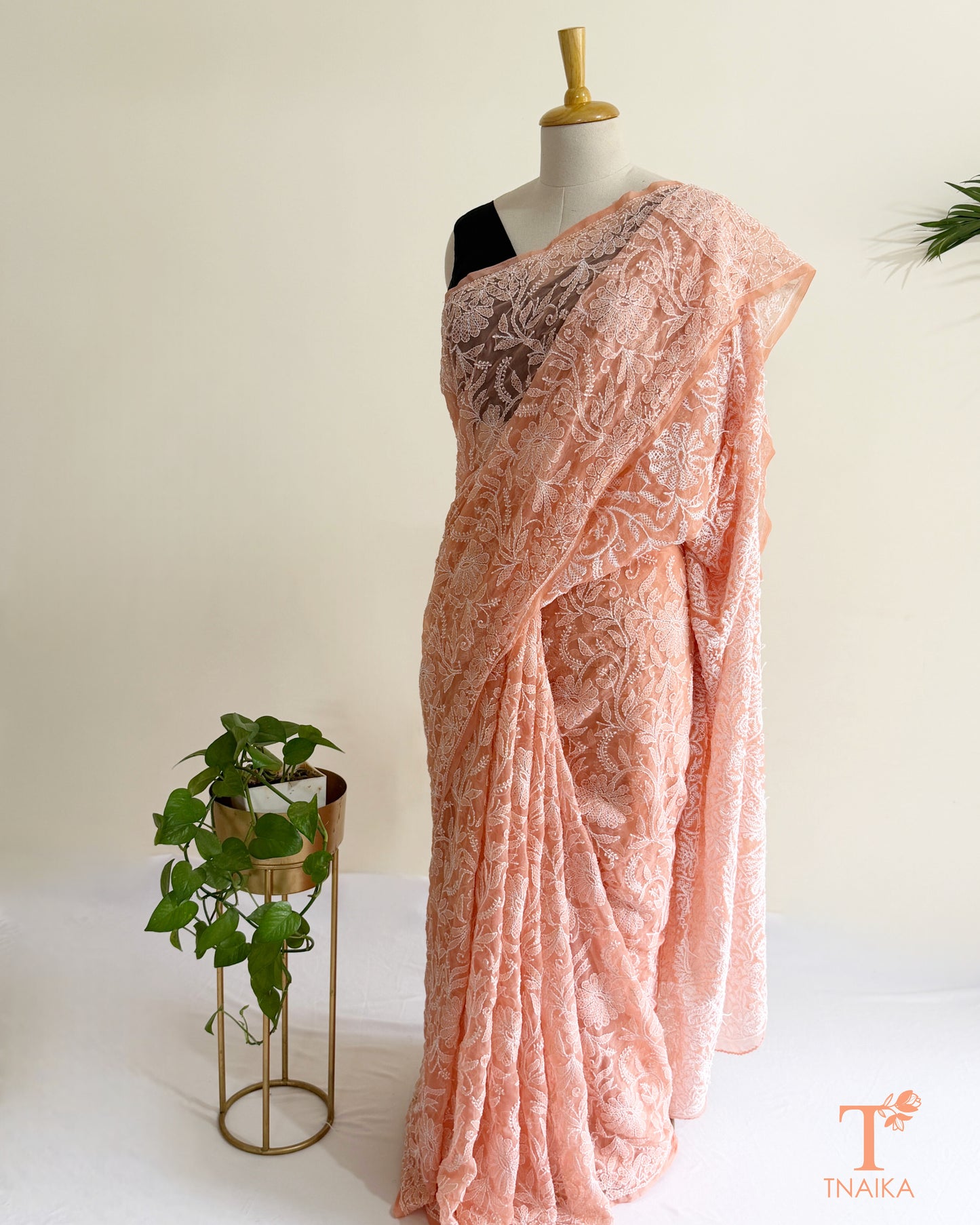 Handcrafted blush pink Chikankari saree with detailed white embroidery, floral vines, and beautifully embroidered borders.